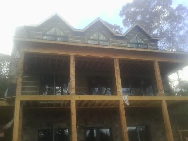 Dormers and porch framing on a large log home under construction — Roof Coating work by our crew in Aspen